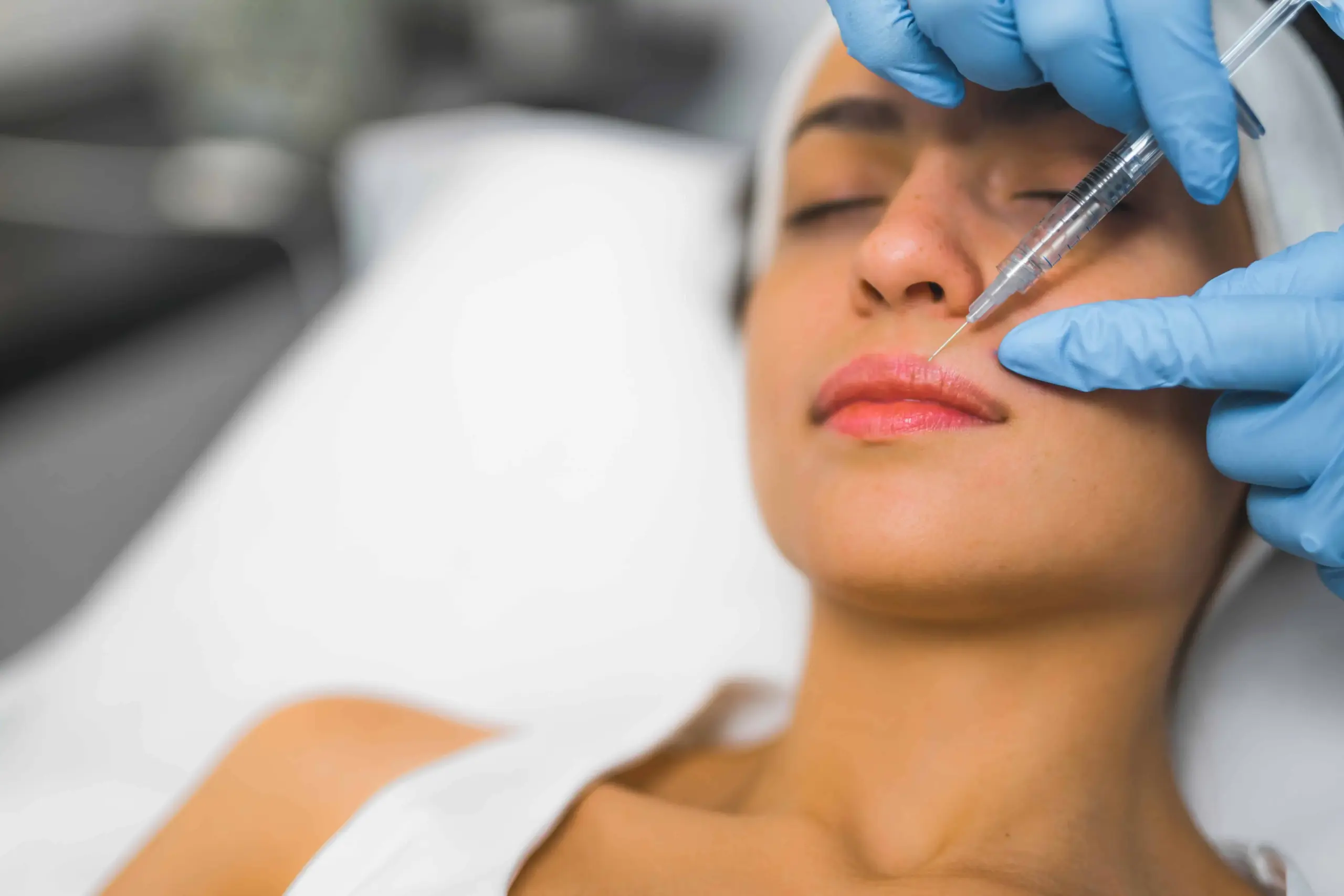 A woman getting getting injection in her lips for fillers